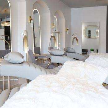 Bright lash room with arched mirrors and soft treatment beds